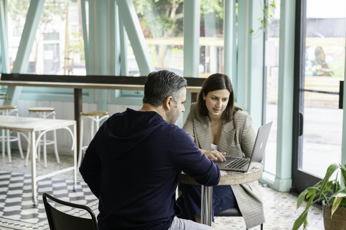 Two business owners reviewing numbers on a laptop